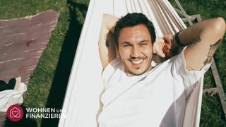 Mann freut sich in der Hängematte über seinen Bauvertrag