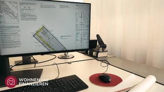 Schreibtisch von Architekt mit Bebauungsplan auf Monitor