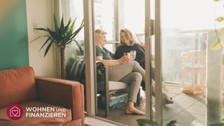 Paar genießt seine Eigentumswohnung auf dem Balkon nach erfolgreichem Wohnungskauf