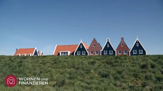 Verschiedene bunte Haustypen hinter einem Deich