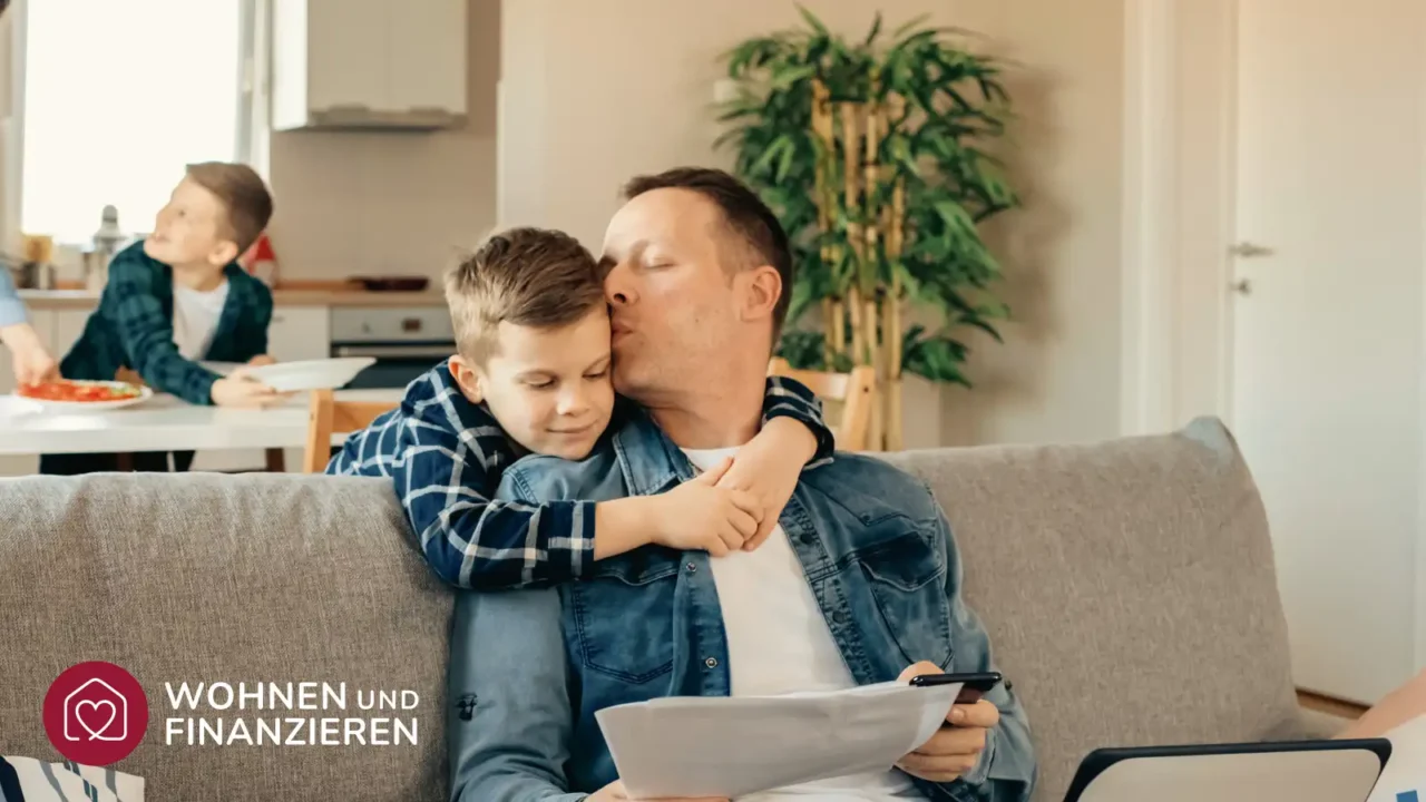 Vater und Sohn informieren sich auf Couch über Bausparvertrag