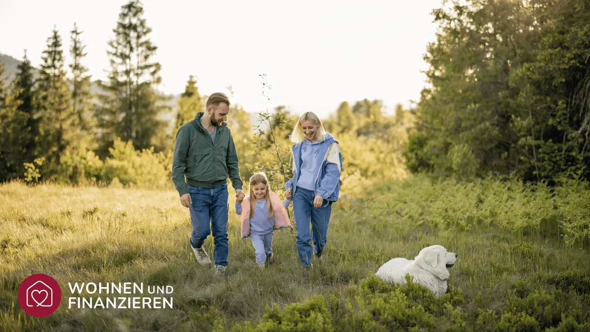 Familie spielt mit Hund im Wald
