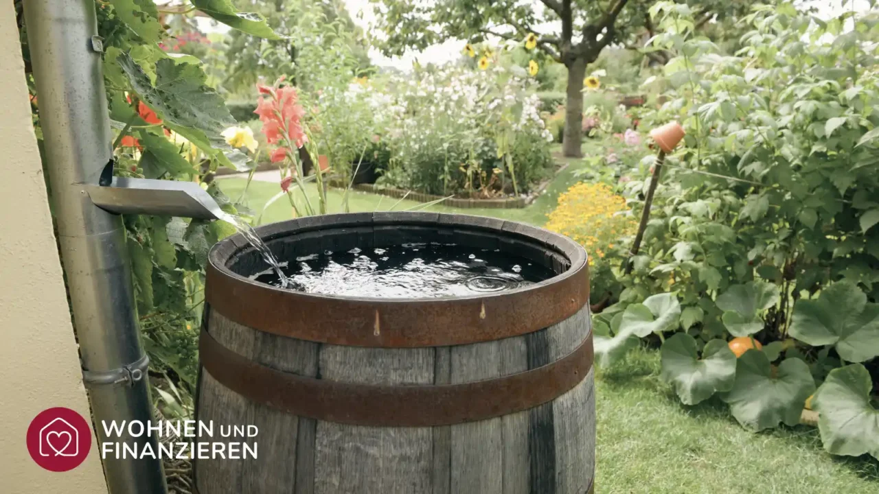 Regentonne in Garten neben dem Wasseranschluss von einem Haus