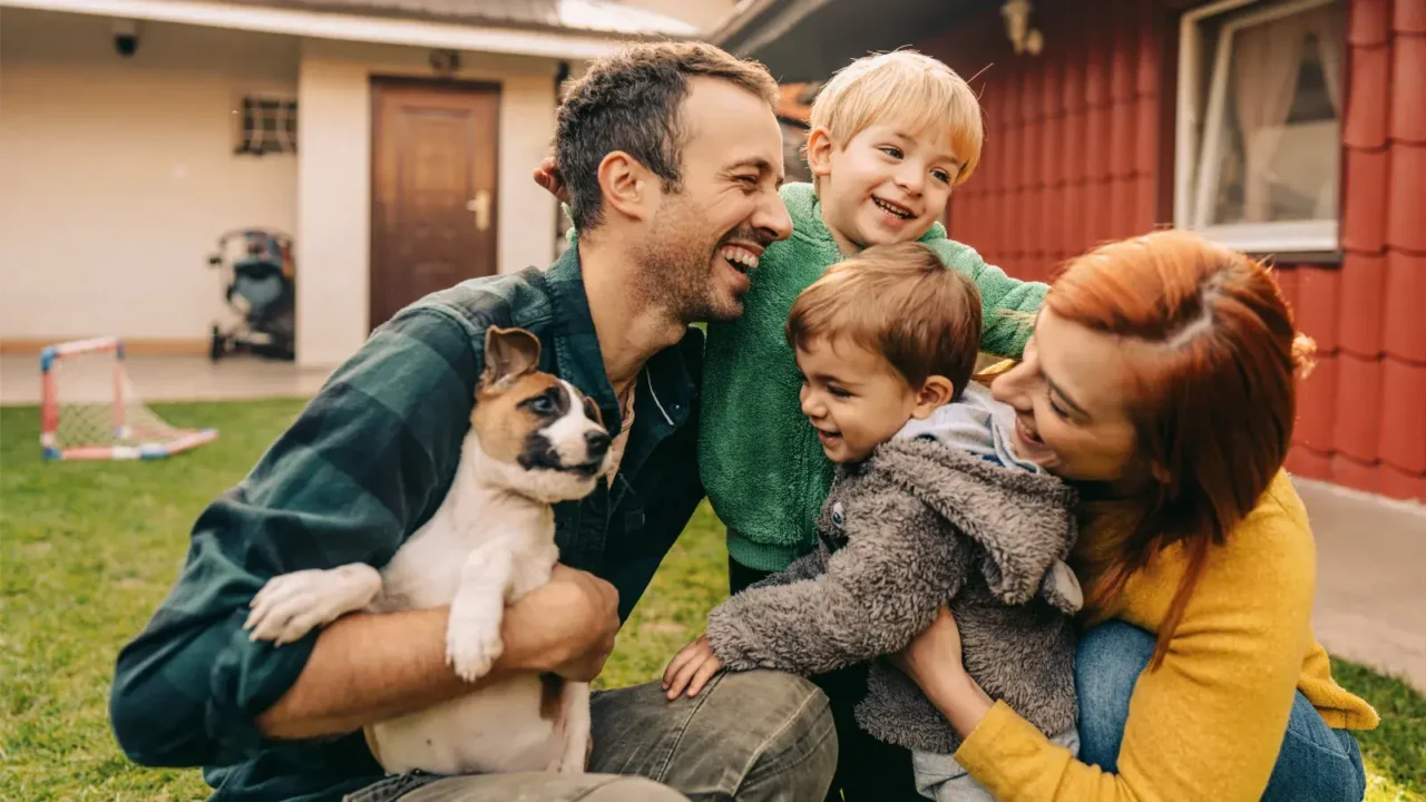 Glückliche Familie mit Hund im Garten