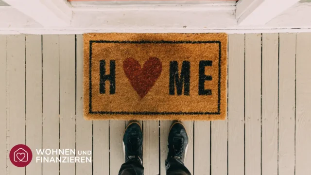 Liebevoll gestaltete Fußmatte vor Eingangstür als Symbol des neue Zuhauses