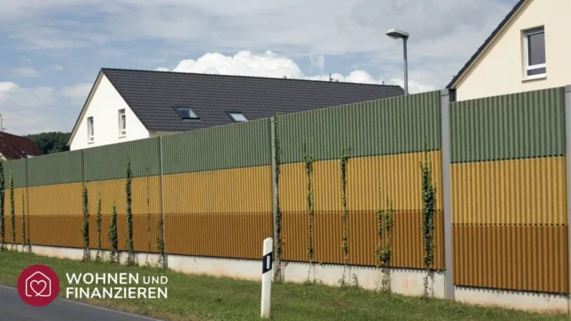 Schallschutzwand zwischen einer Straße und angrenzenden Häusern